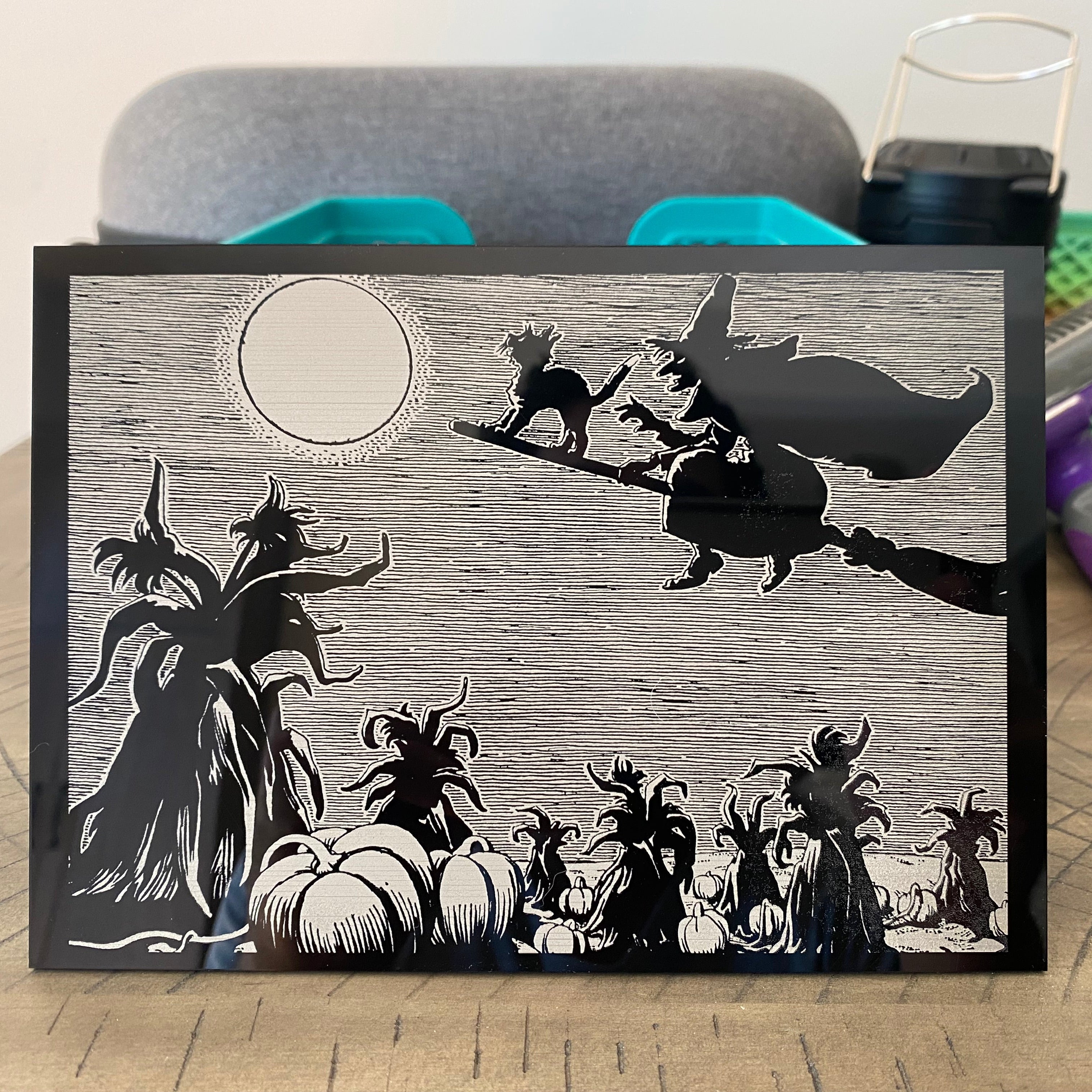 Halloween-themed decorative sign with black and white design on a wooden surface.
