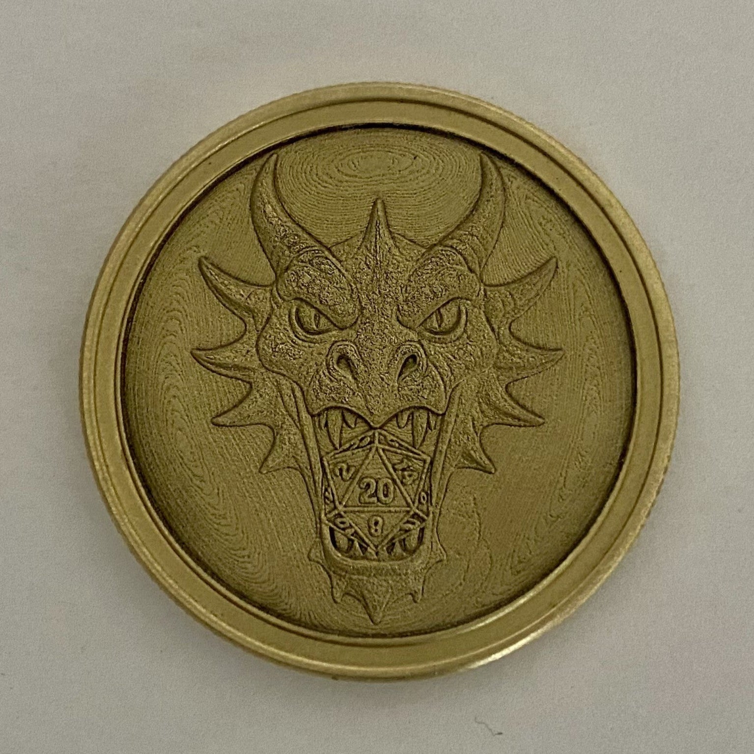 Brass coin with a dragon design on a light gray background