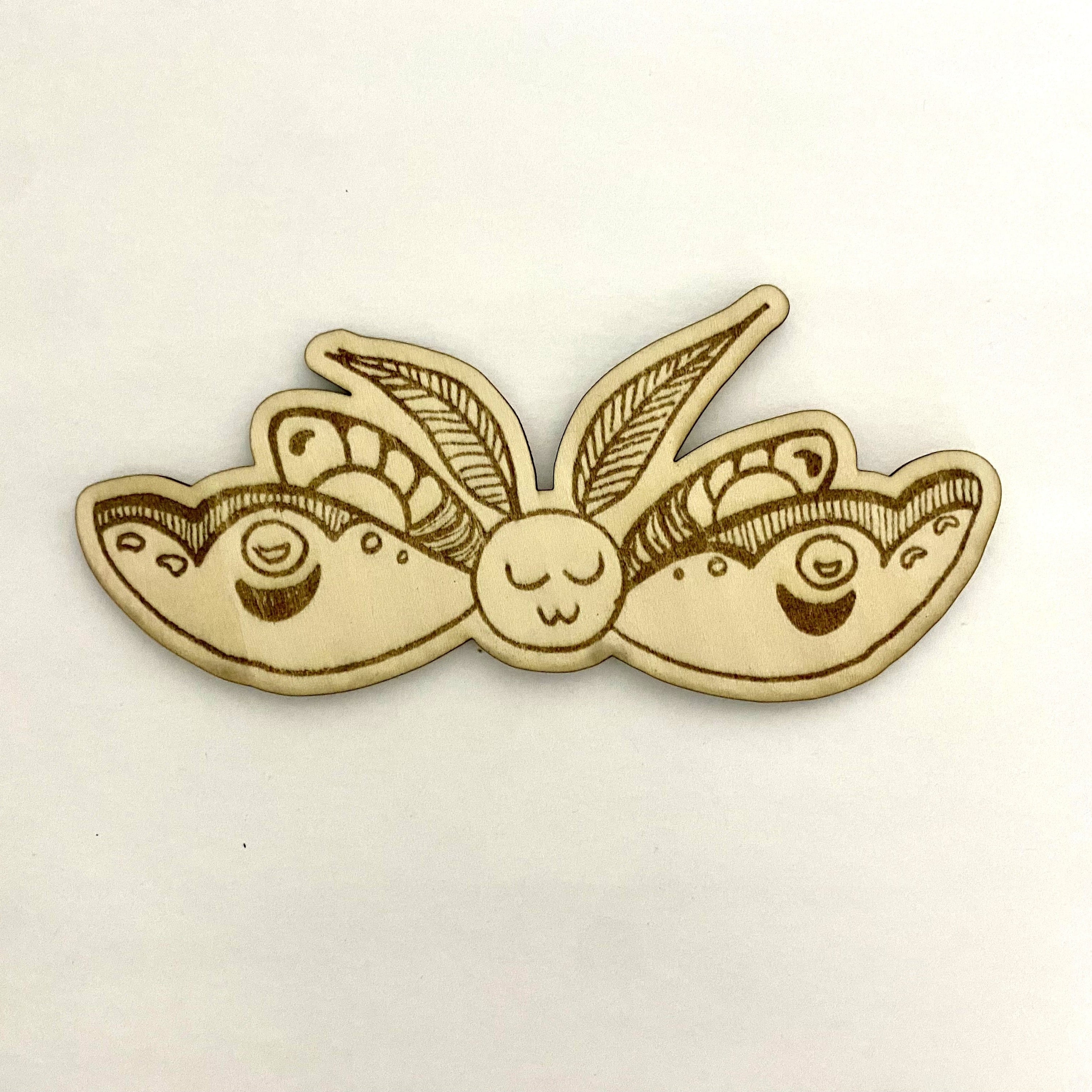 Wooden brooch with butterfly design on a beige background