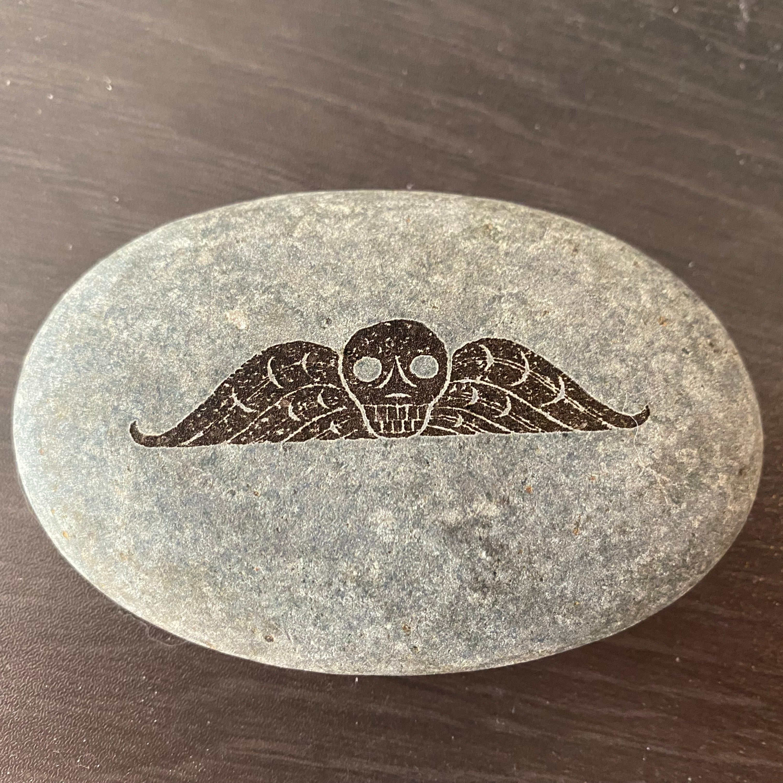 Winged skull on rock